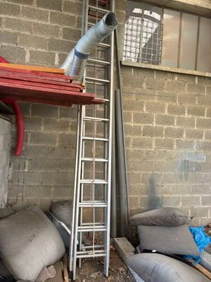 a ladder leaning up against a brick wall next to a pile of pillows