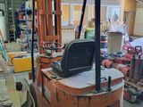 a fork lift truck in a warehouse with many other items