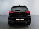 the rear end of a black car in a white room