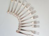 a lot of forks arranged in a circle on the table