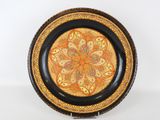 une assiette orange et noire ornée d'un motif décoratif