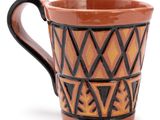 a brown and black cup with a design on it