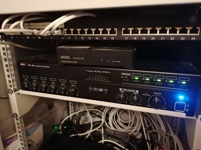 un rack sur lequel sont disposés tout un tas d'appareils électroniques et de câbles