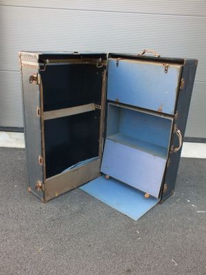 une valise ouverte posée par terre à côté d'une porte de garage