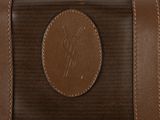 the back of a brown suitcase with a brown leather handle