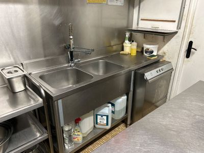 une cuisine en acier inoxydable avec un évier et un lave-vaisselle