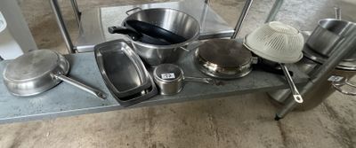 many pots and pans sitting on a metal shelf