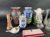 many different vases and other glass items on the table