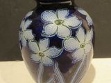 un vase bleu orné de fleurs blanches, posé sur une table