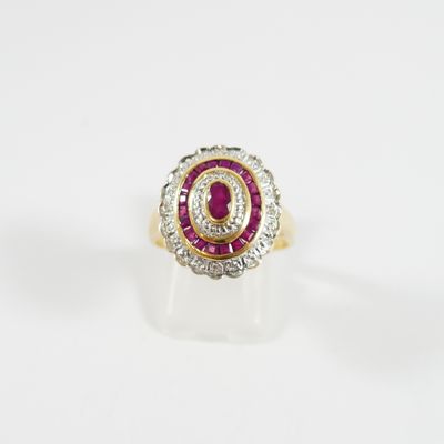 un gros plan d'une bague sertie d'un diamant rouge et blanc sur une surface blanche