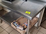 une table en métal sur laquelle se trouve une boîte, dans une cuisine