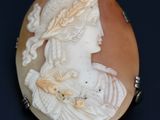 une image représentant le profil d'une femme sur une broche en forme de coquillage