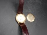 une image représentant une montre-bracelet et une pièce de monnaie posées sur une table