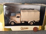 petit camion-jouet dans une boîte, avec une pièce sur le côté