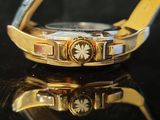 a close up of a gold watch on a black surface