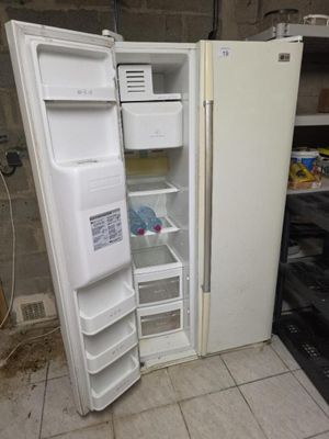 un réfrigérateur blanc dont la porte est ouverte, dans une cuisine