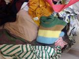 a pile of clothes in a basket on a bed