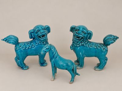 pair of blue ceramic foo foo dog figurines on a white background