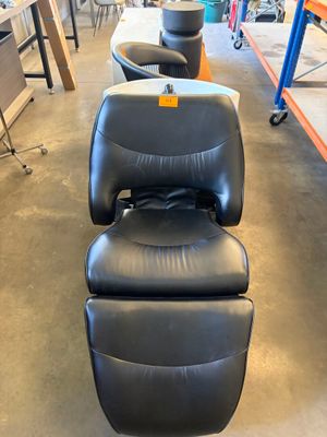 a black leather chair and ottoman in a store