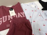 two pairs of pajamas and a t - shirt are laying on a bed