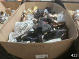 plusieurs paires de chaussures dans une boîte en carton posée sur le sol