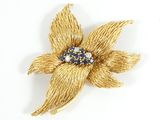 yellow gold tone flower brooch with blue and white stones