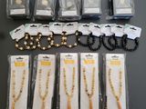 un lot de colliers et de bracelets composés de perles assorties, conditionnés dans des sachets en plastique