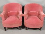 une paire de fauteuils en velours rose avec des pieds et des accoudoirs en bois