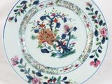 a plate with a floral design on it on a stand
