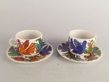deux tasses et soucoupes ornées d'oiseaux et de fleurs colorés