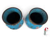 two blue vases sitting next to each other on a white surface