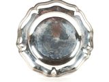une assiette en argent sur fond blanc avec un fond noir