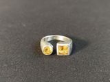 a close up of a silver ring with two yellow stones