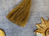 three gold medals and a tassel on a blue cloth