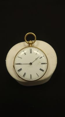 a small white clock with roman numerals on it