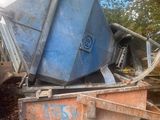 une benne à ordures posée sur un tas de feuilles