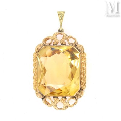 a close up of a pendant with a yellow stone in it