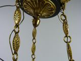 a chandelier with a black and gold design hanging from the ceiling