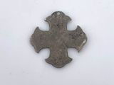 an old silver metal cross on a white surface