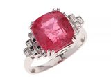 un gros plan d'une bague ornée d'une pierre rose entourée de diamants