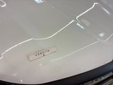 a close up of a white car with a sticker on it