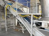 a conveyor belt in a factory with a blue curtain