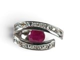 silver ring with a ruby stone and diamonds on a white background