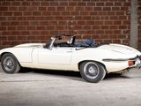 a white sports car parked in front of a brick wall