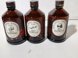 three bottles of syrup sitting on a table next to each other