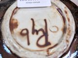 a close up of a brown and white vase with a tag on it