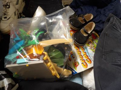 a bag of toys and a pair of shoes on a bed