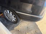 a black car with a flat tire on the side of the road