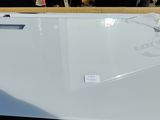 a white refrigerator sitting on top of a wooden table