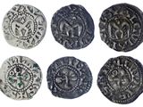 six pièces d'argent anciennes ornées de motifs sur fond blanc